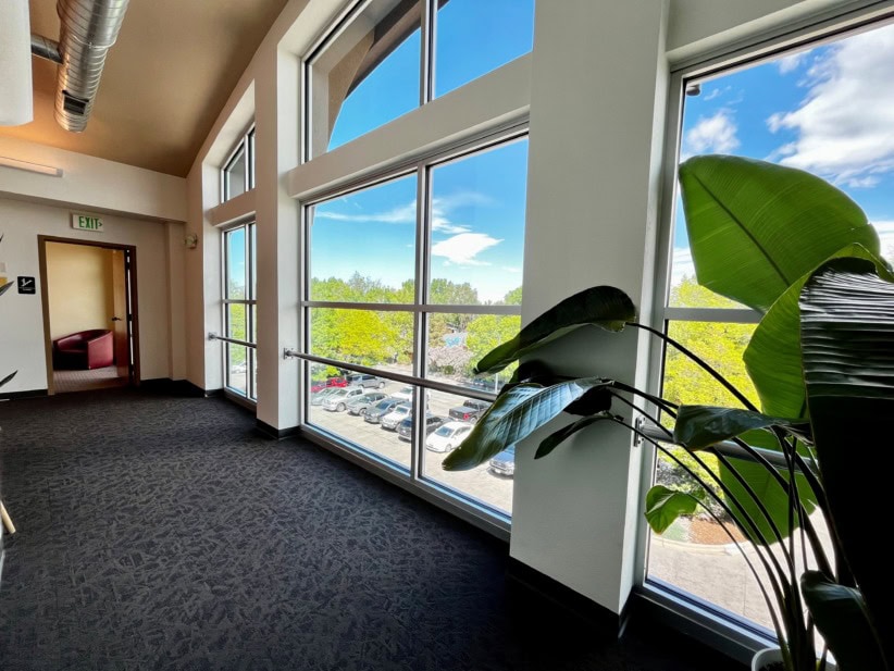 High-rise office space with large windows overlooking Fort Collins cityscape and greenery.