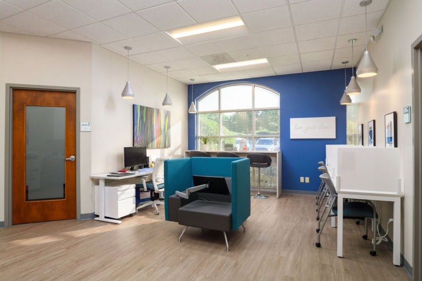 Modern office space with blue accent wall and workstations at Office Evolution.
