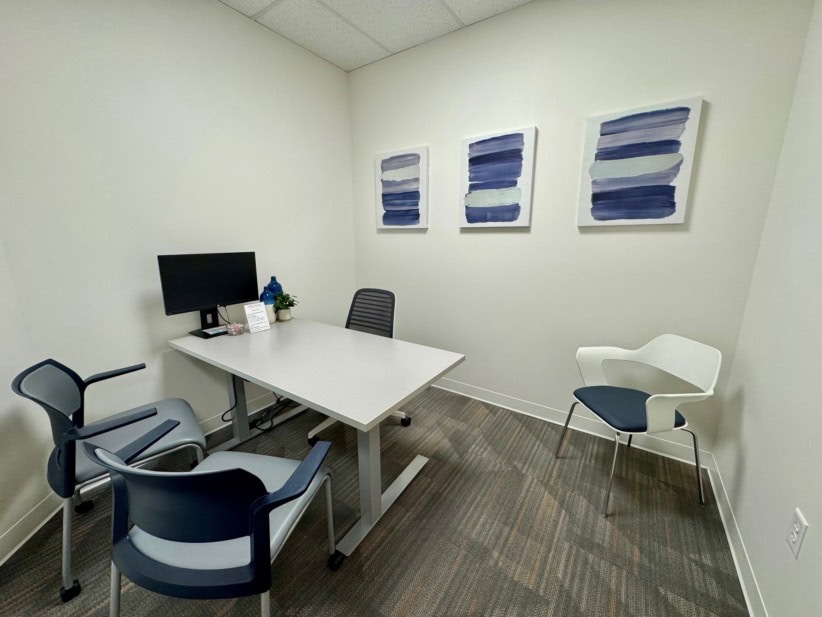 Modern office with white walls, desk, and seating in Denver North/Northglenn.