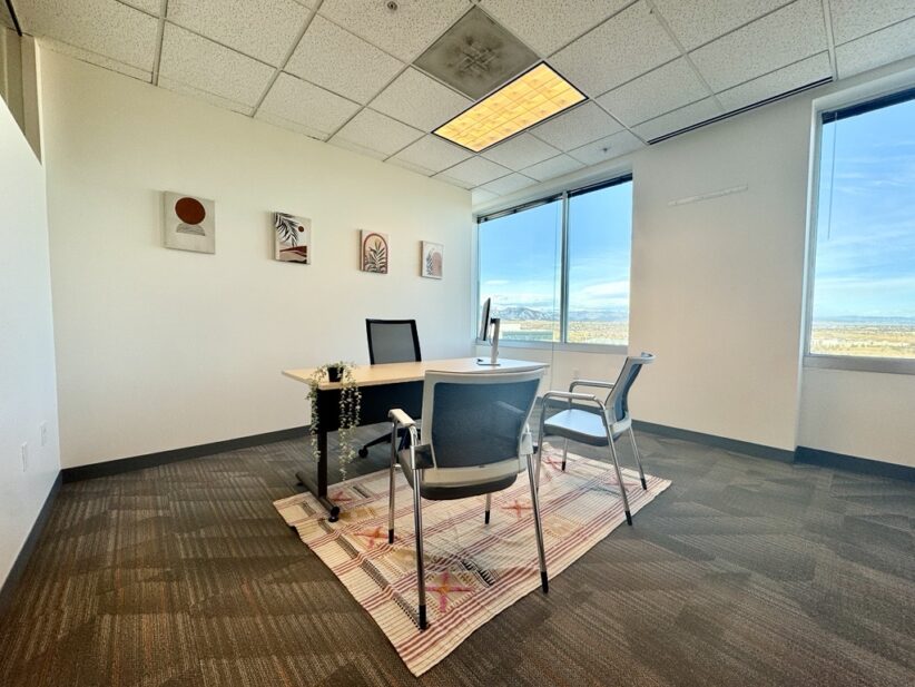 Modern office workspace with large windows and contemporary decor.