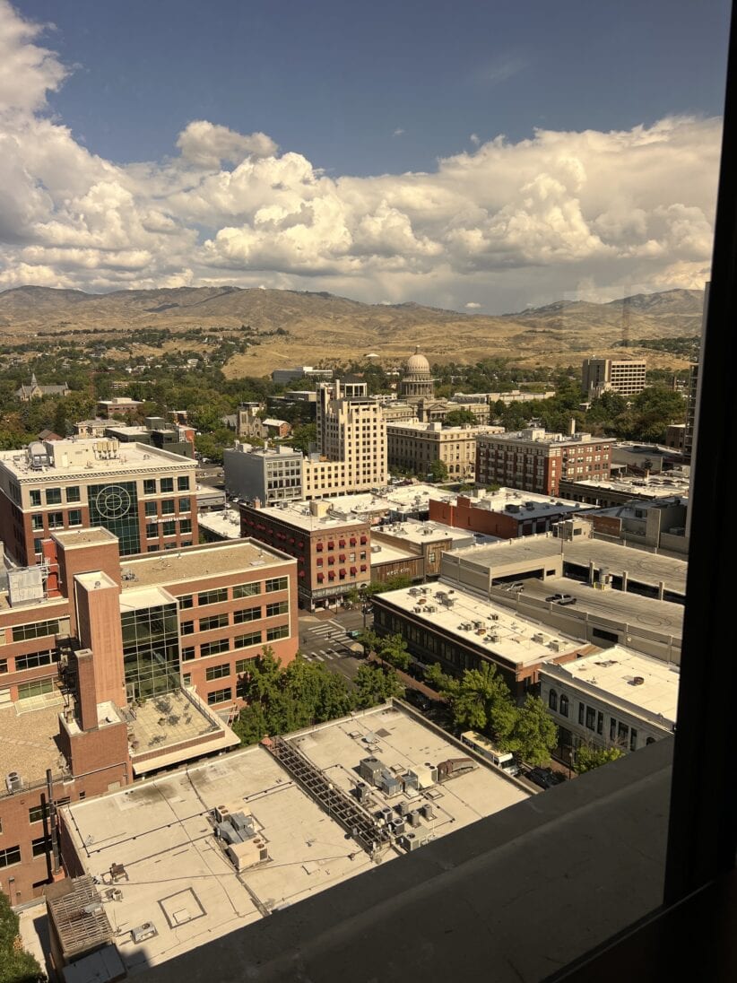 Bright cityscape view of downtown with office buildings, mountains, and sky from Office Evolution coworking space.