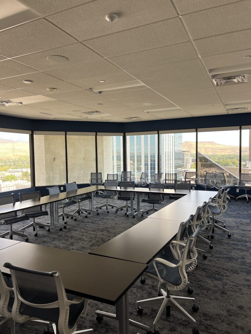 Modern office conference room with large windows and city views, designed for professional meetings.