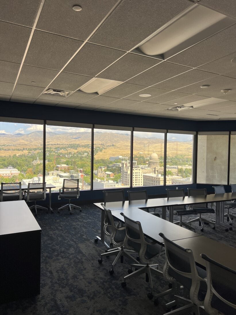 Modern office conference room with panoramic city view and flexible seating arrangements.
