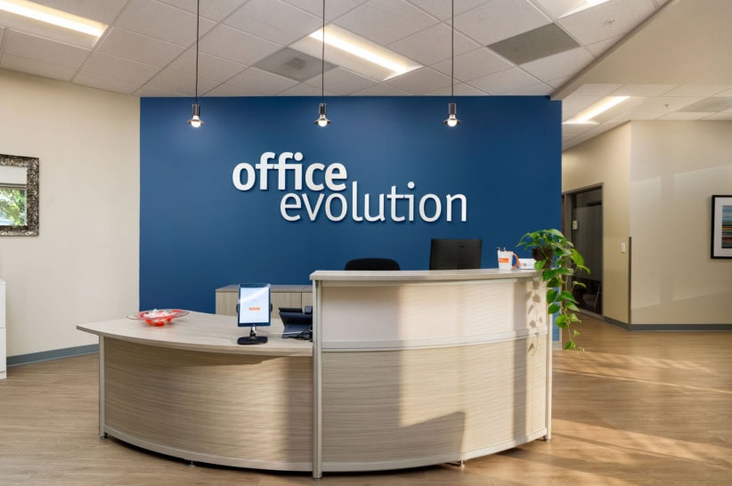 Office Evolution reception area with blue wall and modern decor.