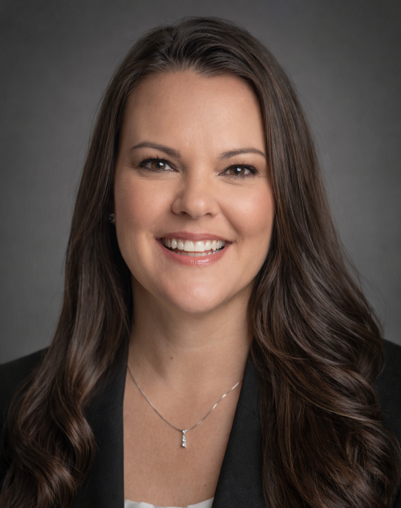 Professional woman with long brown hair smiling in a business portrait.