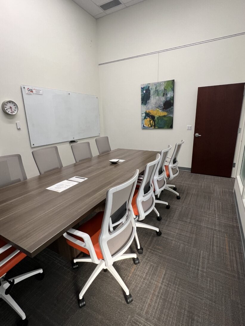 Comfortable industrial-style office conference room with modern chairs and artwork - perfect for meetings and collaboration.
