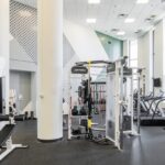 Gym with tall ceilings and excercise equipment including Pelaton.