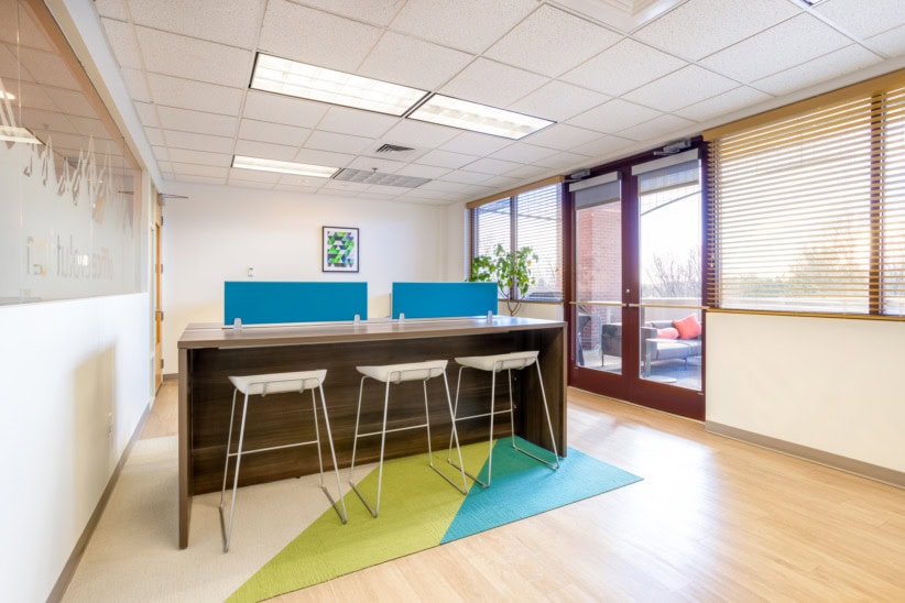 Bright office reception with high counter, seating, and large windows in Louisville.
