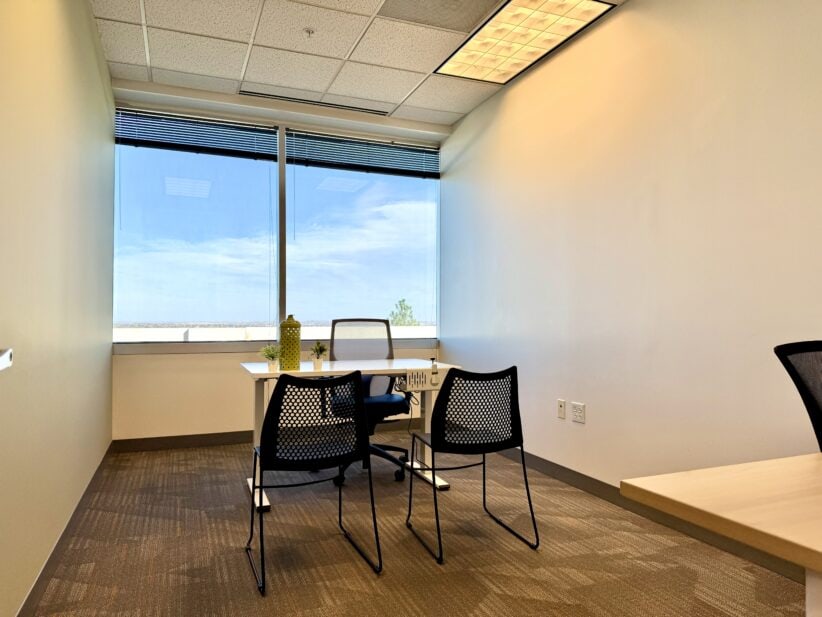 Bright modern office with large window, meeting space, and ergonomic chairs at Office Evolution.