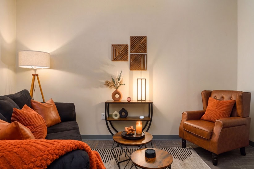 Modern office lounge with cozy seating and warm lighting for productivity.