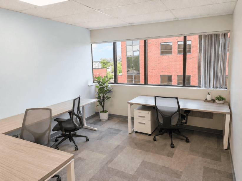 Modern office space with desks, chairs, and large window in Ann Arbor location.