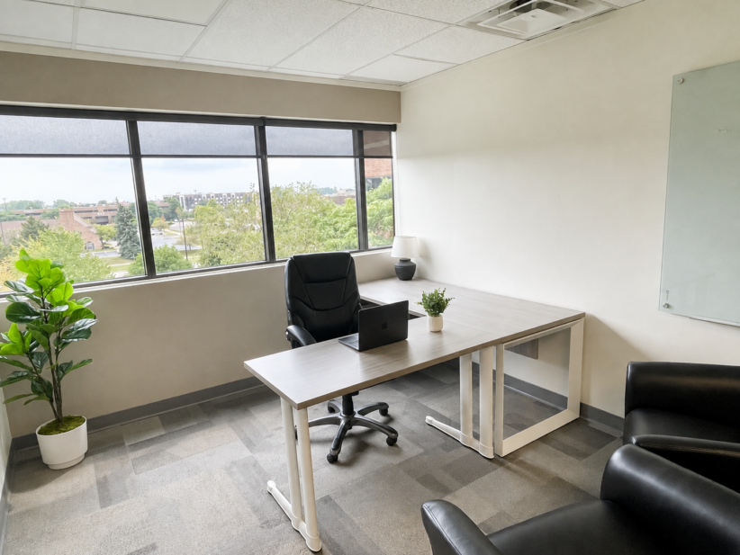 Modern office space with desk, chair, and large window view of Ann Arbor.