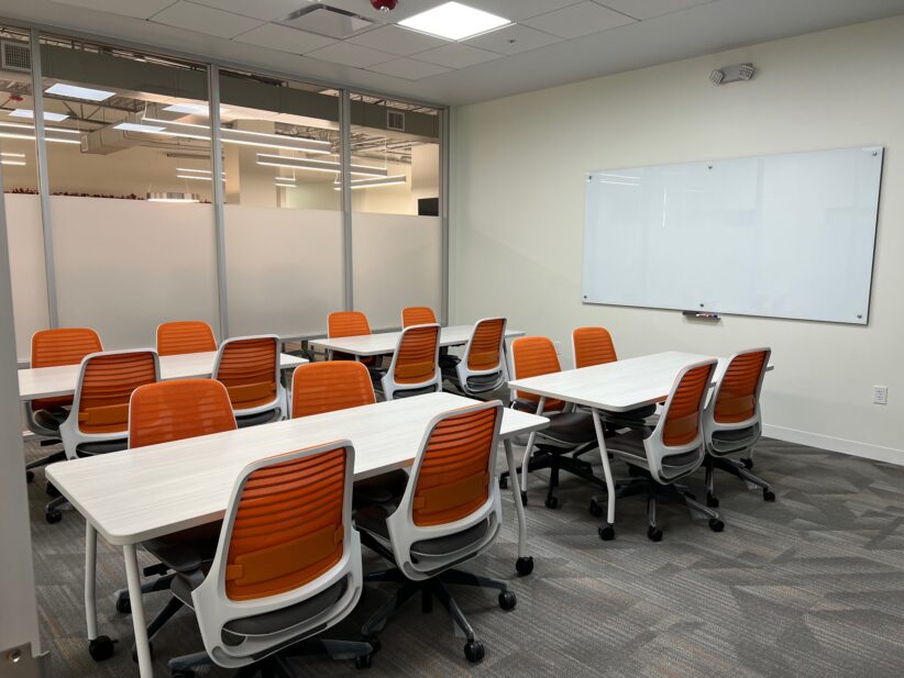 Modern coworking space with collaborative tables and ergonomic chairs in a professional office environment.