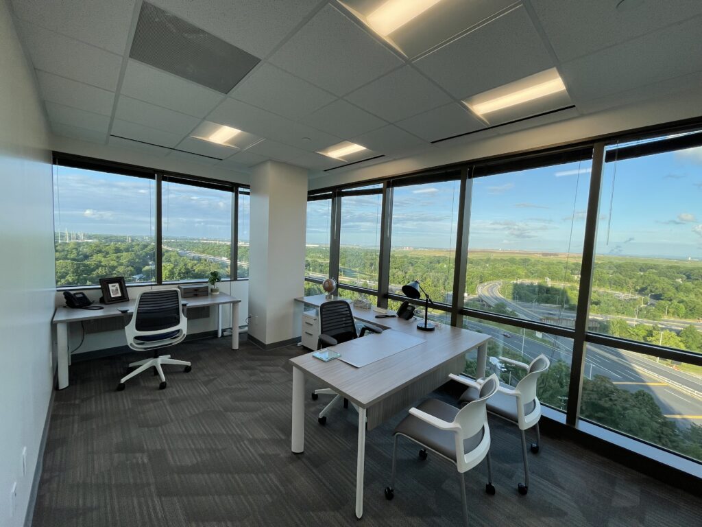 a picture of a shared office space with big windows and a