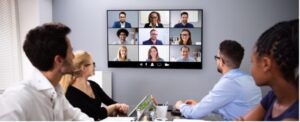 A group of meeting hosting a hybrid meeting.