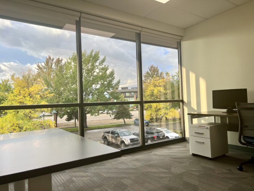 Modern office space with large windows and outdoor view, perfect for coworking and remote work at Office Evolution.