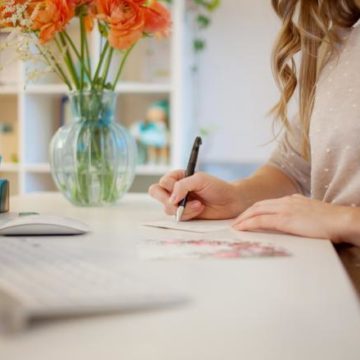 women writing on paper in an office