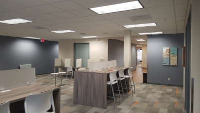 Open office area with counter size desks and chairs.