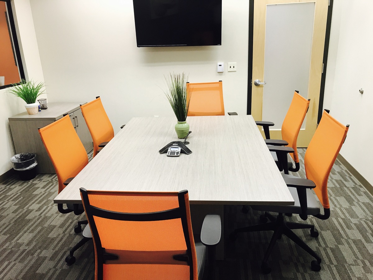 Conference room table with orange chairs.