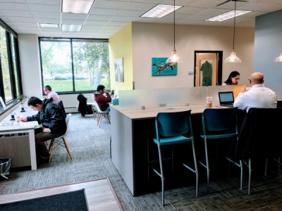 Open office workspace with large windows and long office tables.