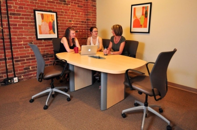 Group of women meeting at a conference table.