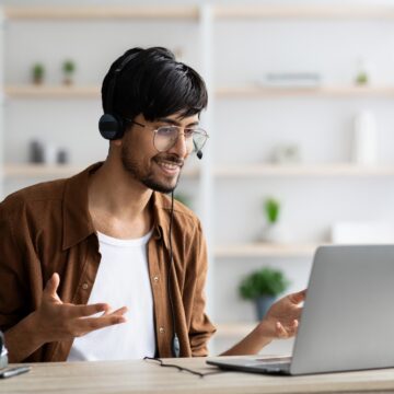 Image of Indian man smiling and talking with an interviewer in an online job interview