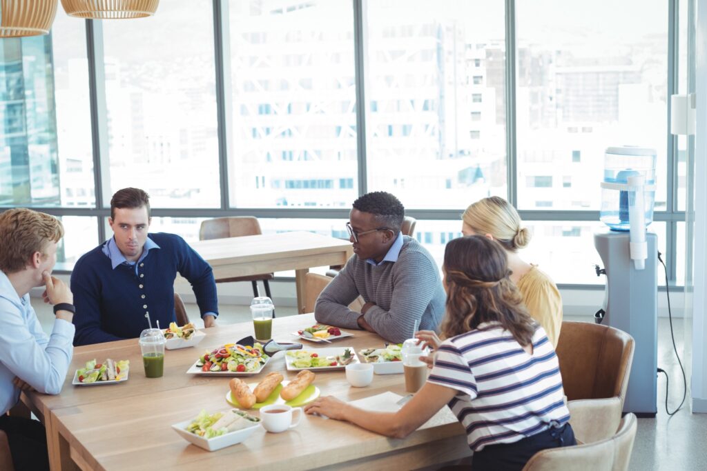 Image of four office workers having lunch in break room