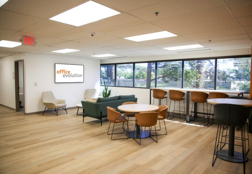 Modern coworking office lounge with comfortable seating and large windows, perfect for productive work sessions.