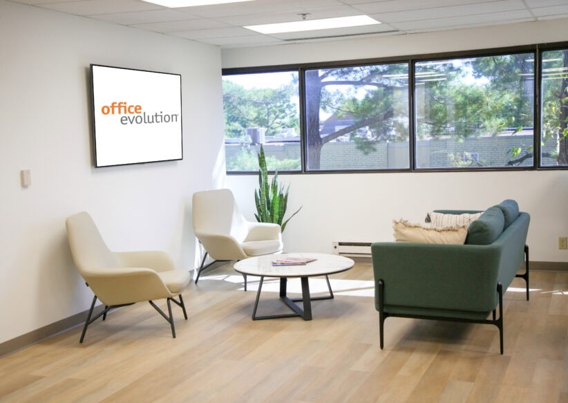 Comfortable office lounge area with modern seating and large windows, promoting productive coworking and business meetings.