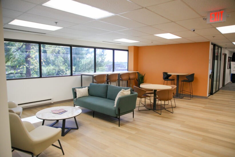Modern coworking lounge with comfortable seating and large windows at Office Evolution.