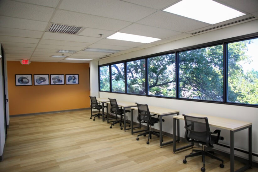 Modern office coworking space with large windows and comfortable chairs for productive work sessions.