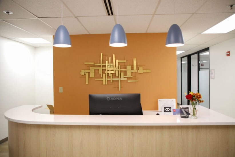 Modern office reception desk with stylish decor and lighting at Office Evolution.