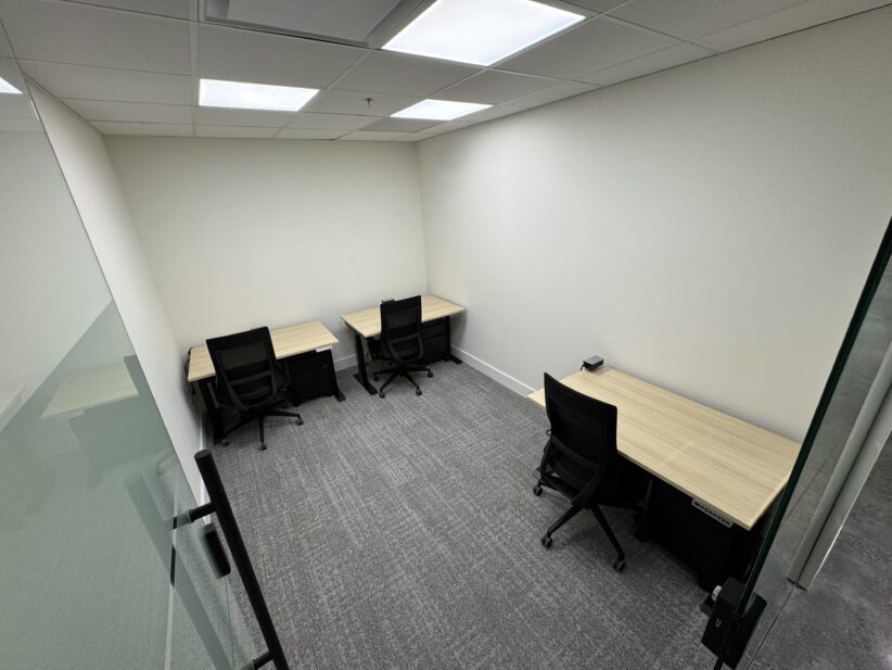 Quiet private office space with three workstations and ergonomic chairs for remote and in-person work.