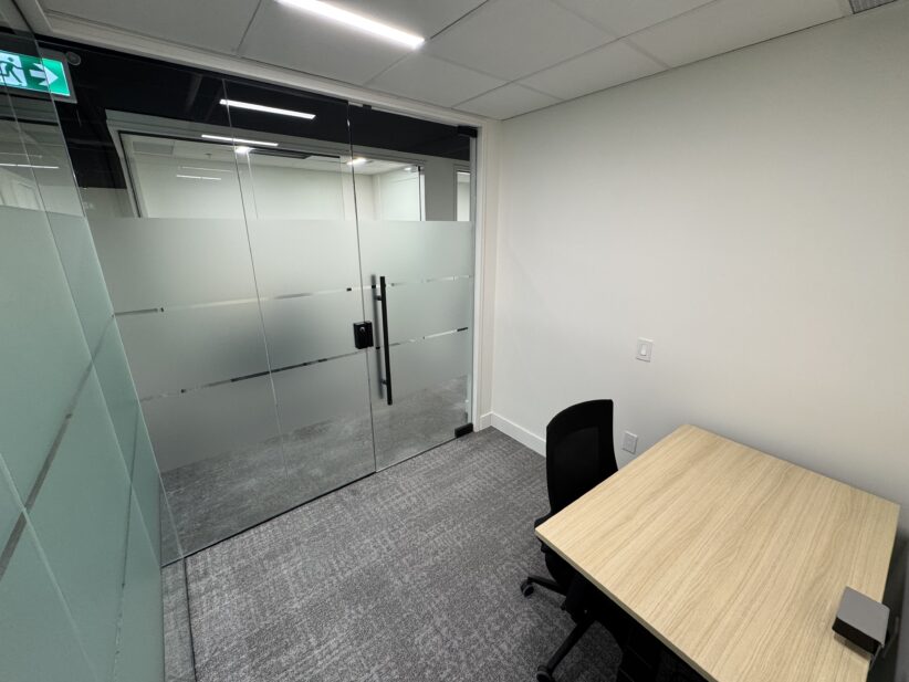 Modern private office space with glass doors at Office Evolution coworking facility.