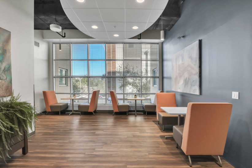 Modern office lounge with comfortable seating and large windows at Office Evolution.