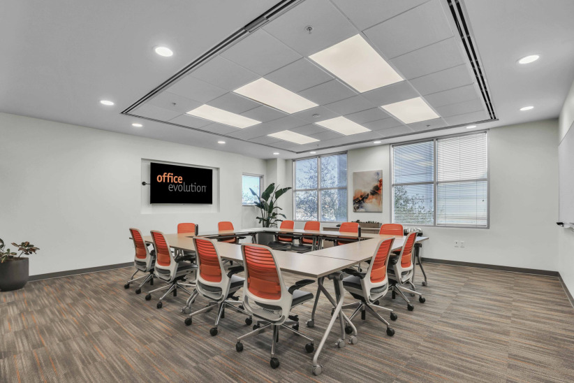 Modern office meeting room with collaborative workspace and bright natural lighting.