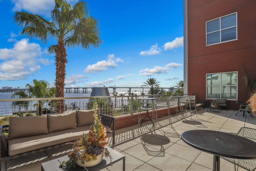 Modern outdoor office space overlooking water with comfortable seating and scenic views.