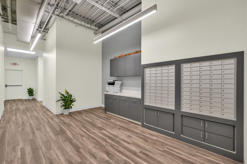 Mailbox area with mailboxes and office amenities in modern coworking space.