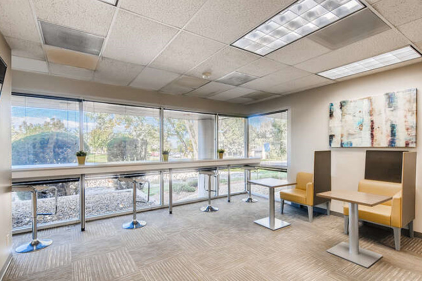 Modern office lounge with large windows and comfortable seating at Office Evolution.