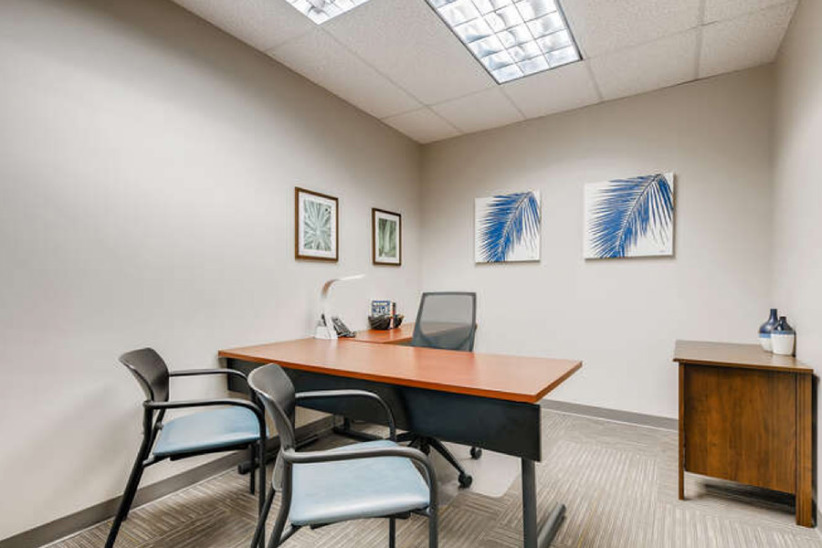 Conference room with office furniture and tropical wall art at Office Evolution.
