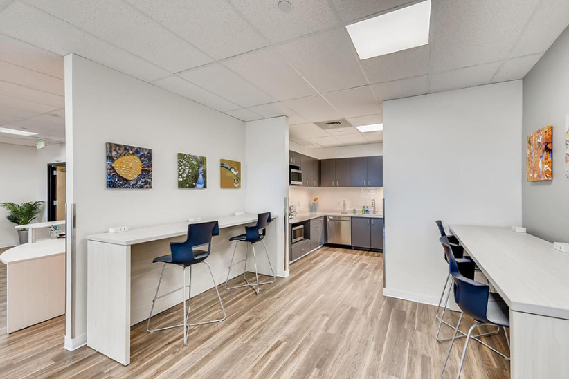 Modern shared office workspace with seating and kitchen area at Office Evolution.