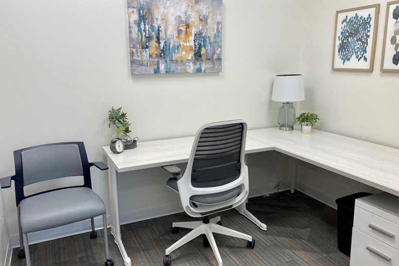 Modern office workspace with ergonomic chair, minimalist decor, and versatile furniture for professional environments.