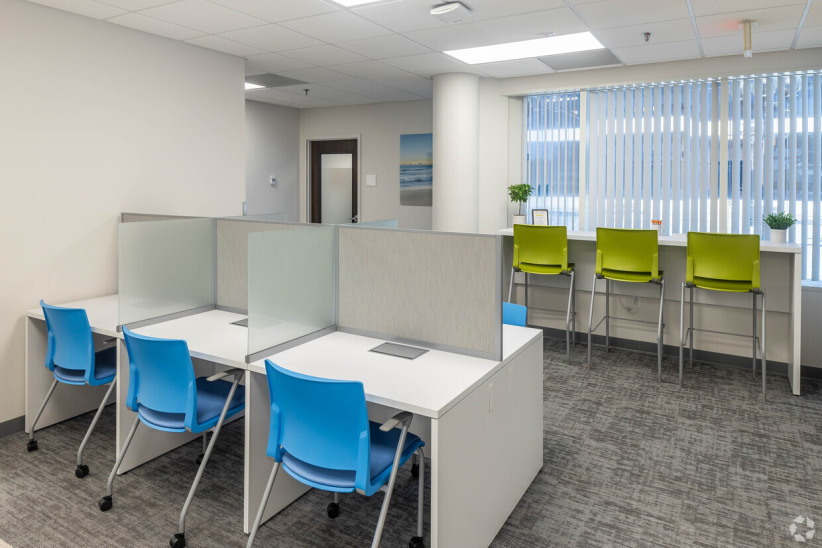 Modern shared office workspace with cubicles and seating for coworking or remote work.