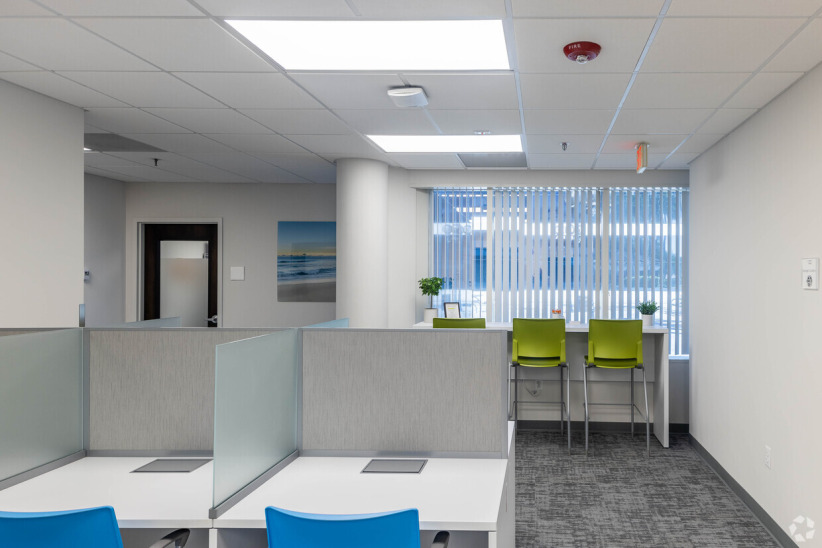 Office evolution coworking space with modern workstations and bright natural lighting, flexible office solutions in a professional environment.