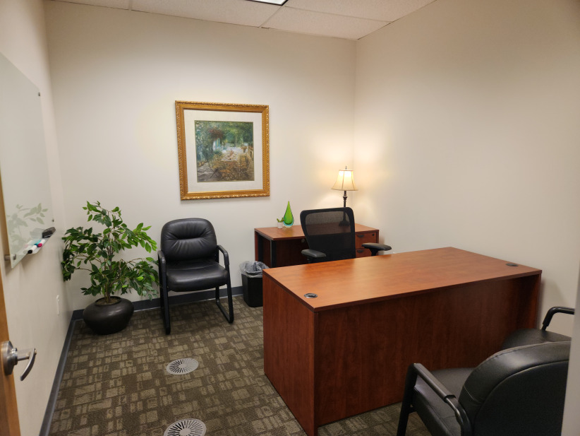 Modern private office space at Office Evolution with comfortable seating and professional ambiance.
