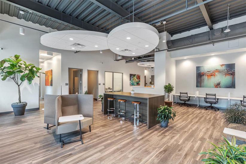 Modern office lounge with seating area, artwork, and natural lighting for productive workspaces.