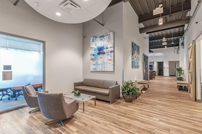 Modern office lobby with comfortable seating and contemporary artwork, ideal for client meetings and waiting areas at Office Evolution.