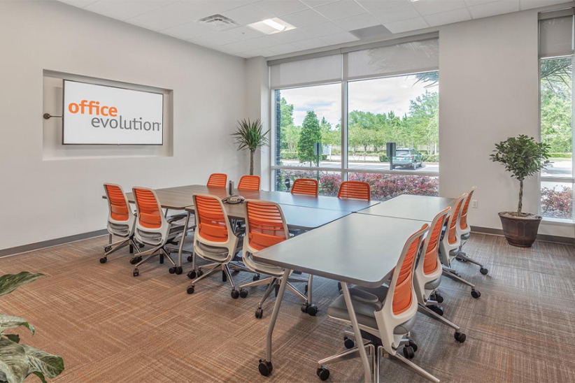 Modern coworking office meeting room with conference tables and ergonomic chairs, perfect for business teams.