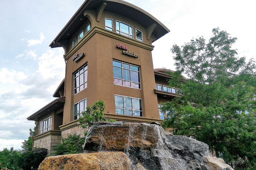 Office evolution coworking space exterior with waterfall feature and modern design.