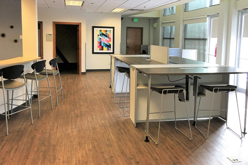 Co-working office space with high-top desks and barstools at Office Evolution, modern shared workspace for professionals.